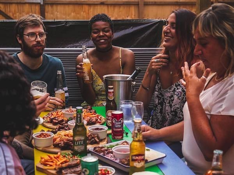 A Group Of Happy Friends Enjoying Chakalaka South African Outdoor Dining In The Northern Quarter Manchester