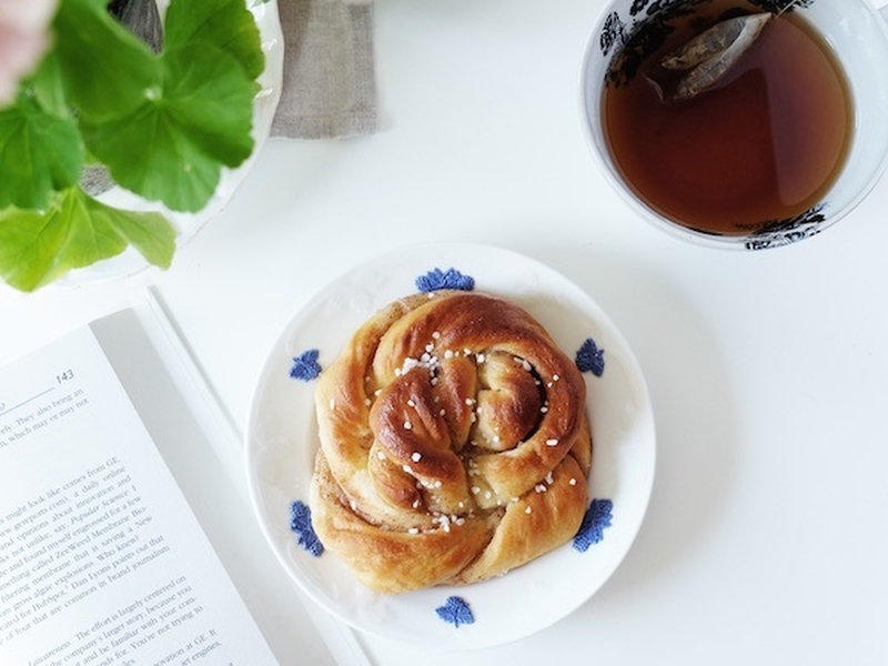 A Nordic Style Bun And A Cup Of Tea With A Cookery Book