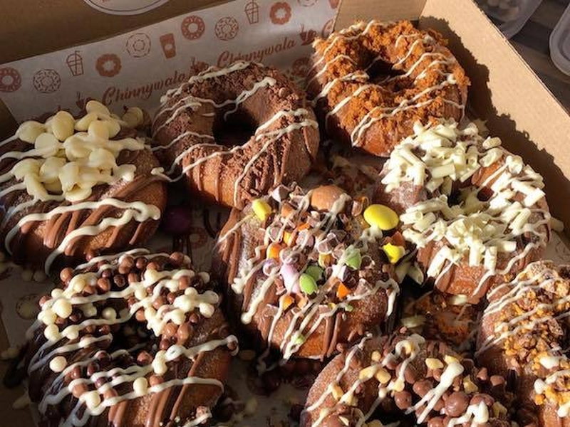 A Box Of Doughnuts From Chinnywala In Longsight Manchester With A Range Of Indulgent Chocolate Sprinkle Toppings And Chocolate Sauce