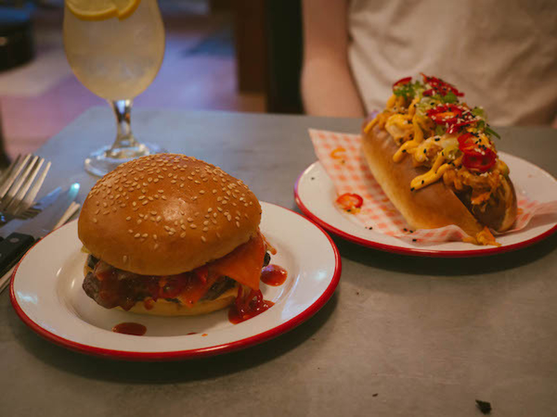 The Big Kim Hotdog With Kimchi And Sriarcha Mustard And The Chilli Cheese Burger With Extensive Chopped Chilli Coverage And American Cheese Both From Mustard Diner Altrincham Manchester