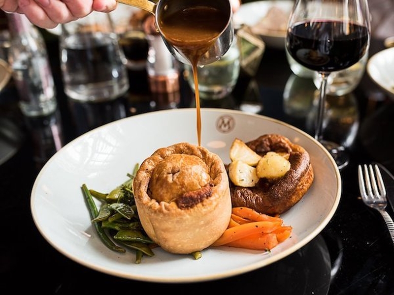 Gravy Being Poured Onto A Pie Some Carrots Beans And A Yorkshire Pudding At Masons Bar And Restaurant On Bridge Street In Manchester