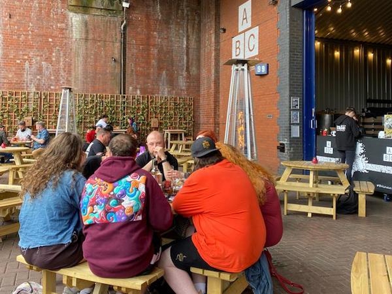 People Drinking Outside At Alphabet Brewing Company Tap Room In Manchester
