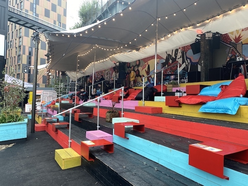 Brightly Coloured Step And Beanbag Seating Area Outdoors At Frieght Island Manchester Which Has A New Brew Tap From Pomona Island