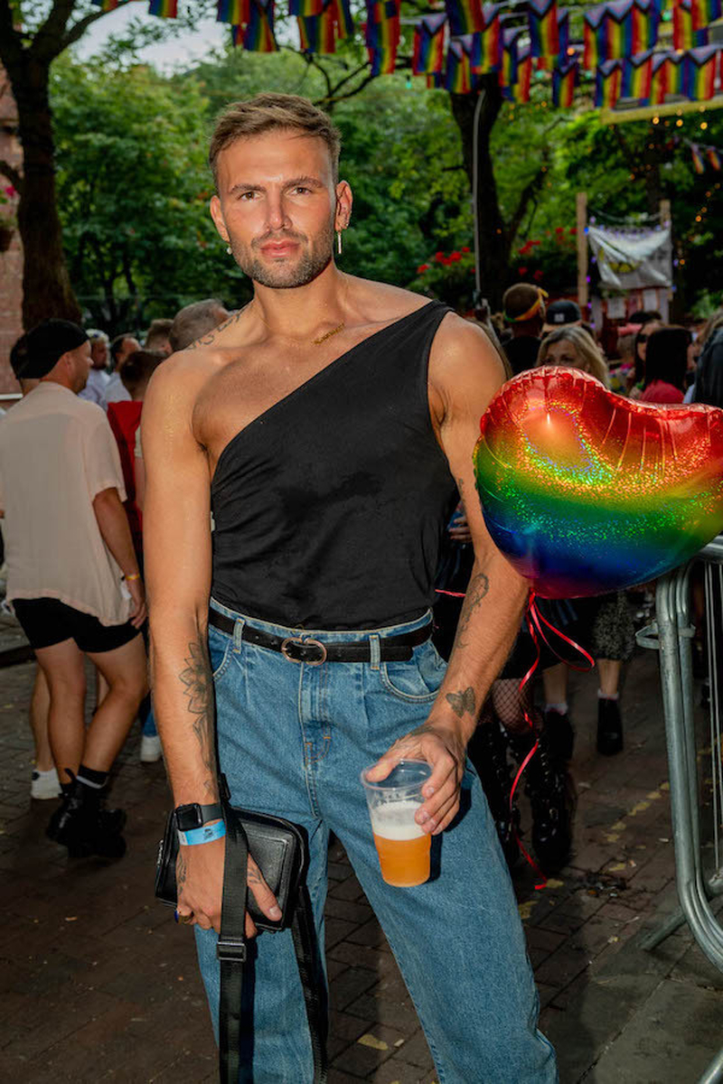 A Man Wearing An Off The Shoulder Top Holding A Rianbow Balloon At Manchester Pride 2021 Chris Keller Jackson