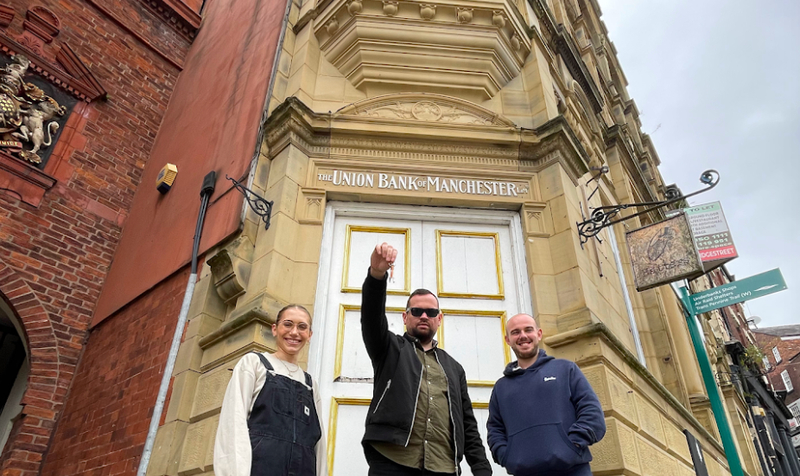 The owners of This Godless Place and The Good Rebel standing outside the old Union Bank of Manchester