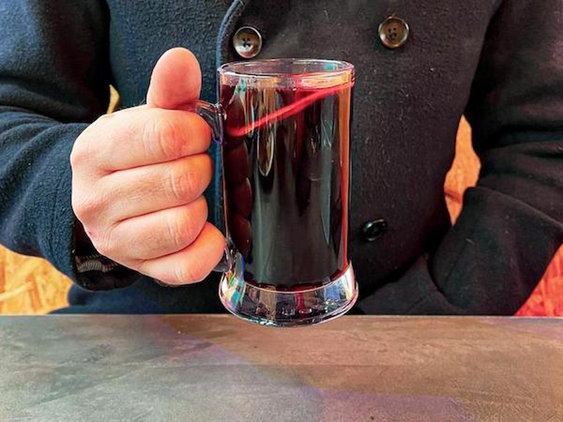 A Man In A Warm Coat Holds A Mug Of Mulled Wine At Winter Island From Escape To Freight Island