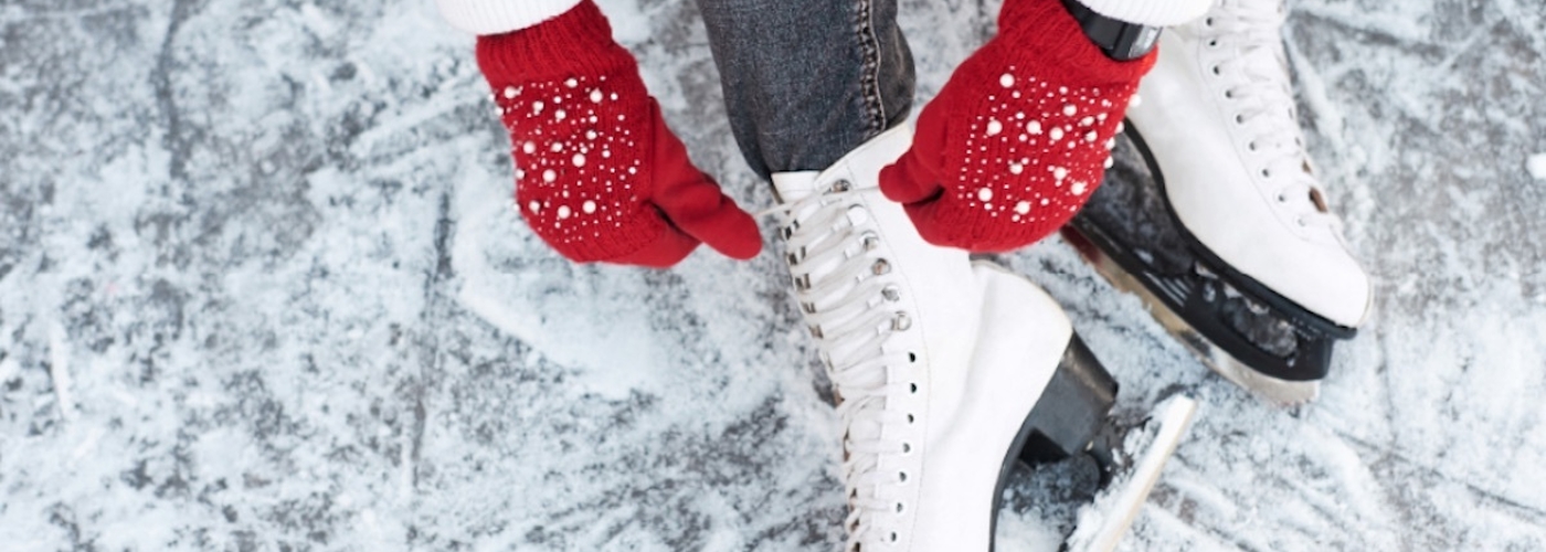 Ice Skater Tying Laces On The Ice