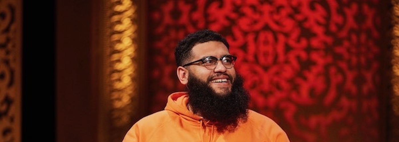 Jamali Maddix In An Orange Jumper Smiling