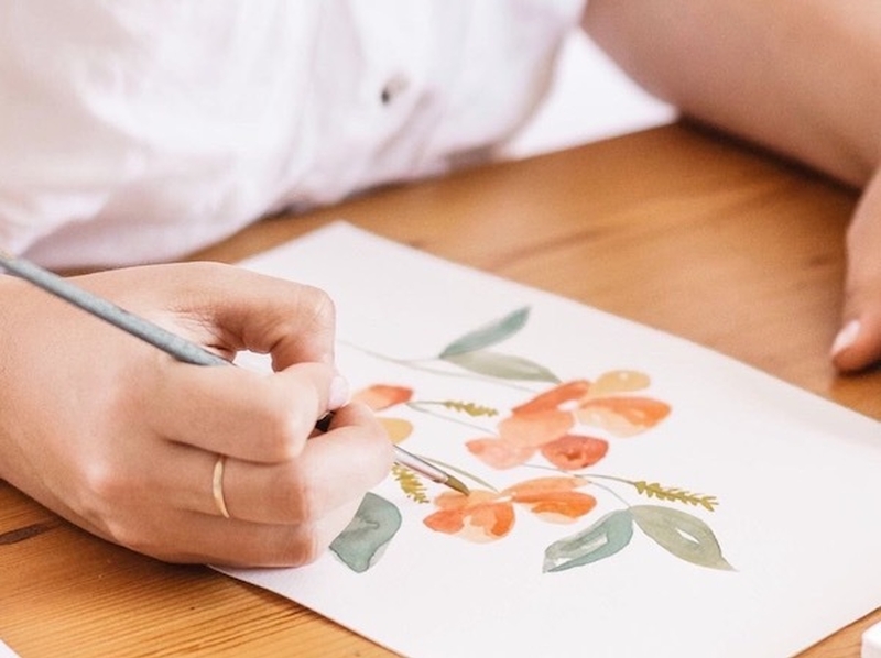 A Person Works On A Watercolour Picture Of Orange Flowers