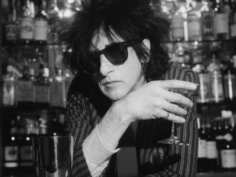 John Cooper Clarke Leads Over A Bar Drink In Hand He Will Perform Live In Leeds This March