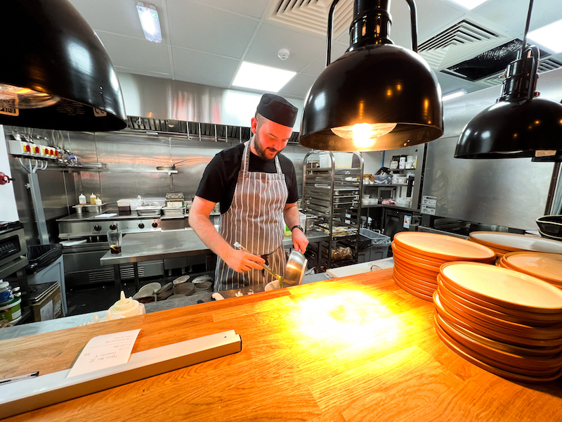 A Chef Prepaes Food In The Kitchen At Green In Sale