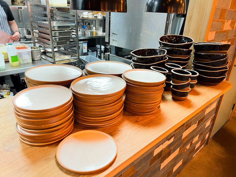 Plates And Bowls Stacked In The Kitchen At Greens In Sale Greater Manchester