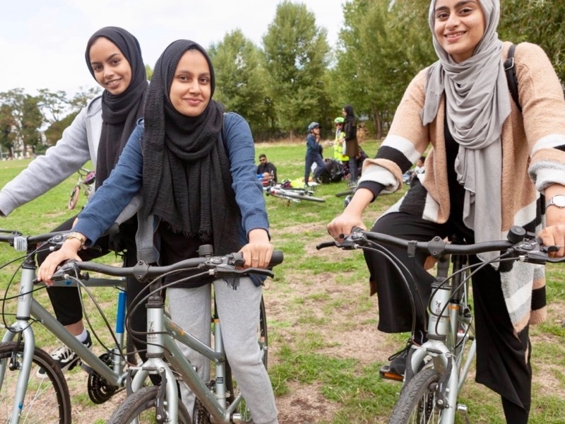 JoyRiders Manchester three girls on bikes in park
