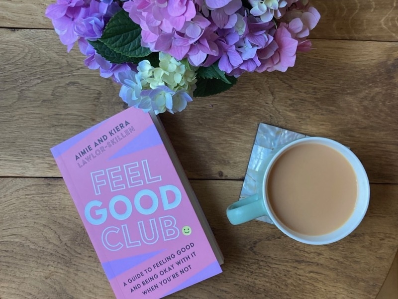 Feel Good Club book on a table with a cup of tea