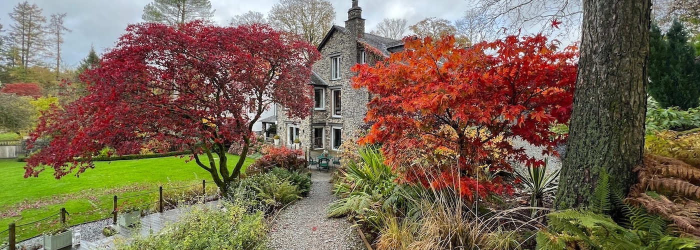 Gilpin Lodge Lakehouse Surrounded By Beauitful Gardens With Trees In Autumn Colours