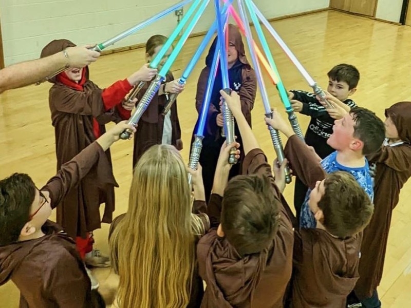 Children saluting with lightsabers at a Ludosport children's party in Manchester