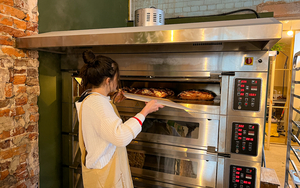 Rosie Wilkes From Yellowhammer Pulling A Sourlough Loaf Out Of The Oven