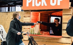A Woman On A Bike Picks Up Her Order At Meatless Farm Barbecue Drive Thru