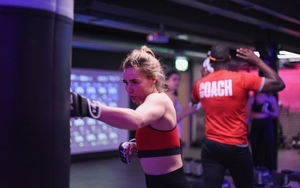 Girl hitting a punch bag at a V1BE boxing class